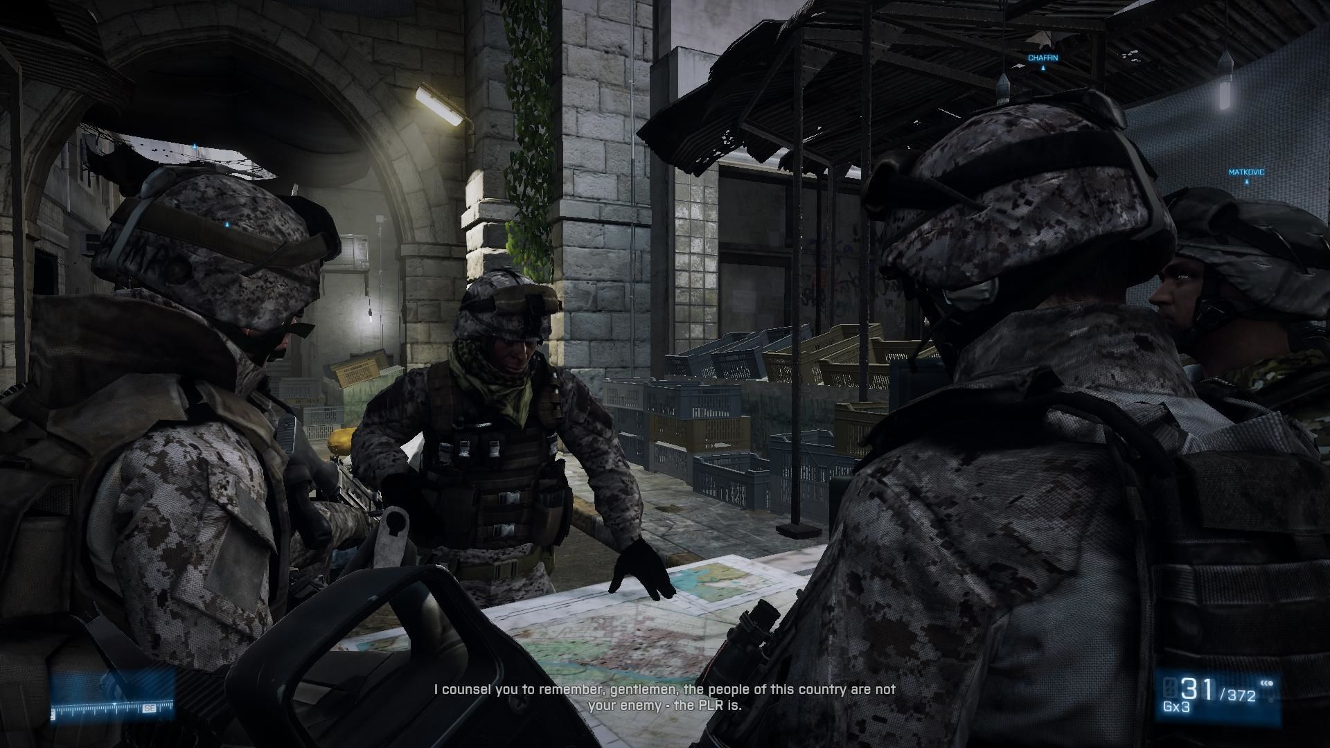 Four soldiers being briefed on mission while looking at a map.