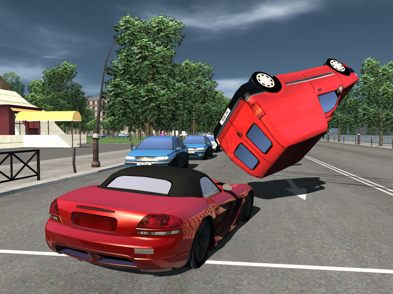 Two red cars, one is upside down in mid air.